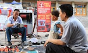县城修鞋个体户王宁生，二十多年来，坚持学雷锋做好事，为老红军、军人、残疾人、烈军属等义务修鞋，受到群众的好评。图为，王宁生正在为一市民修鞋